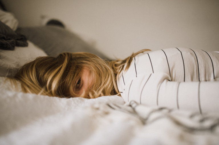 A woman rests from burn out on a bed