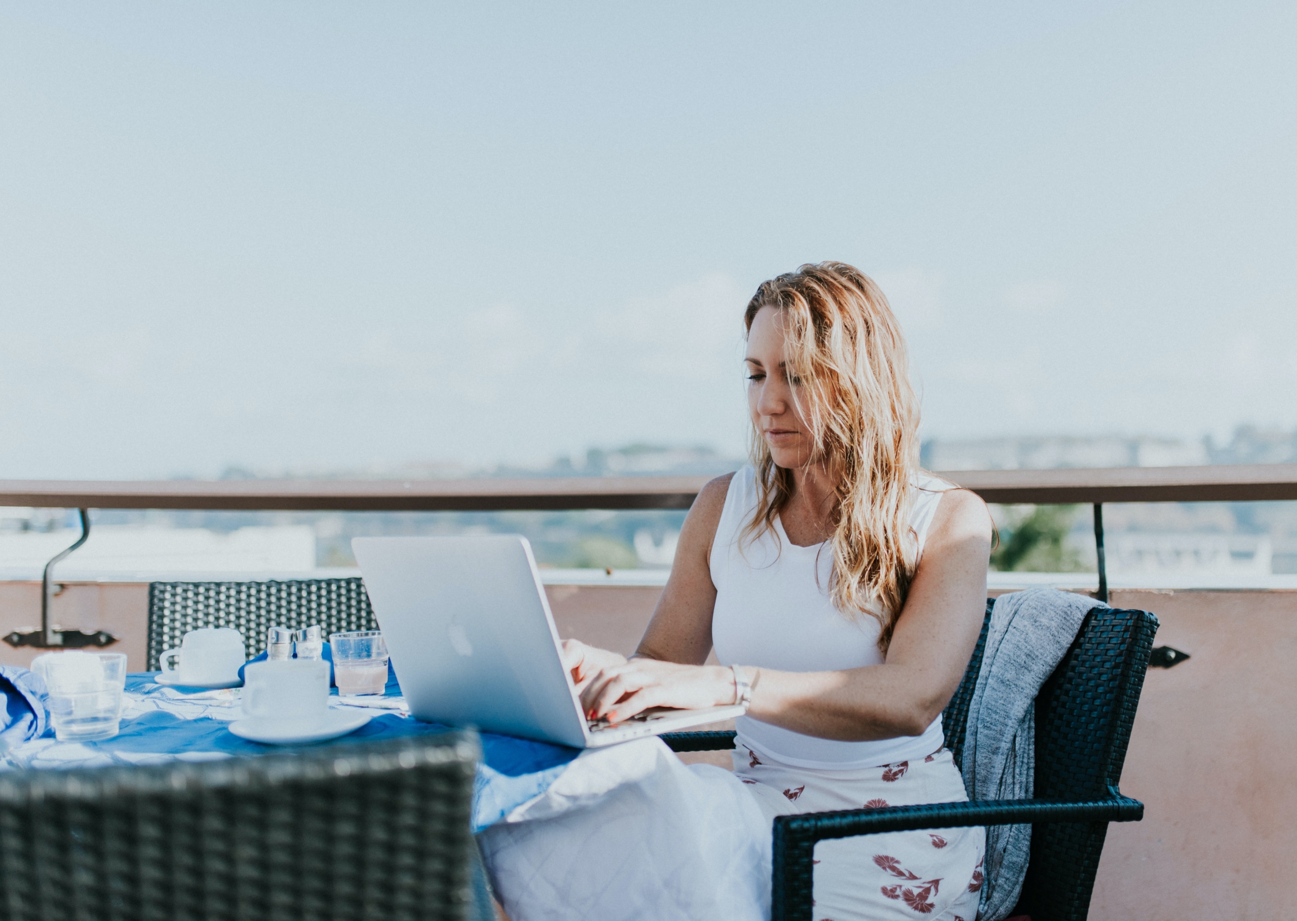 A digital nomad works from a table on a balcony abroad