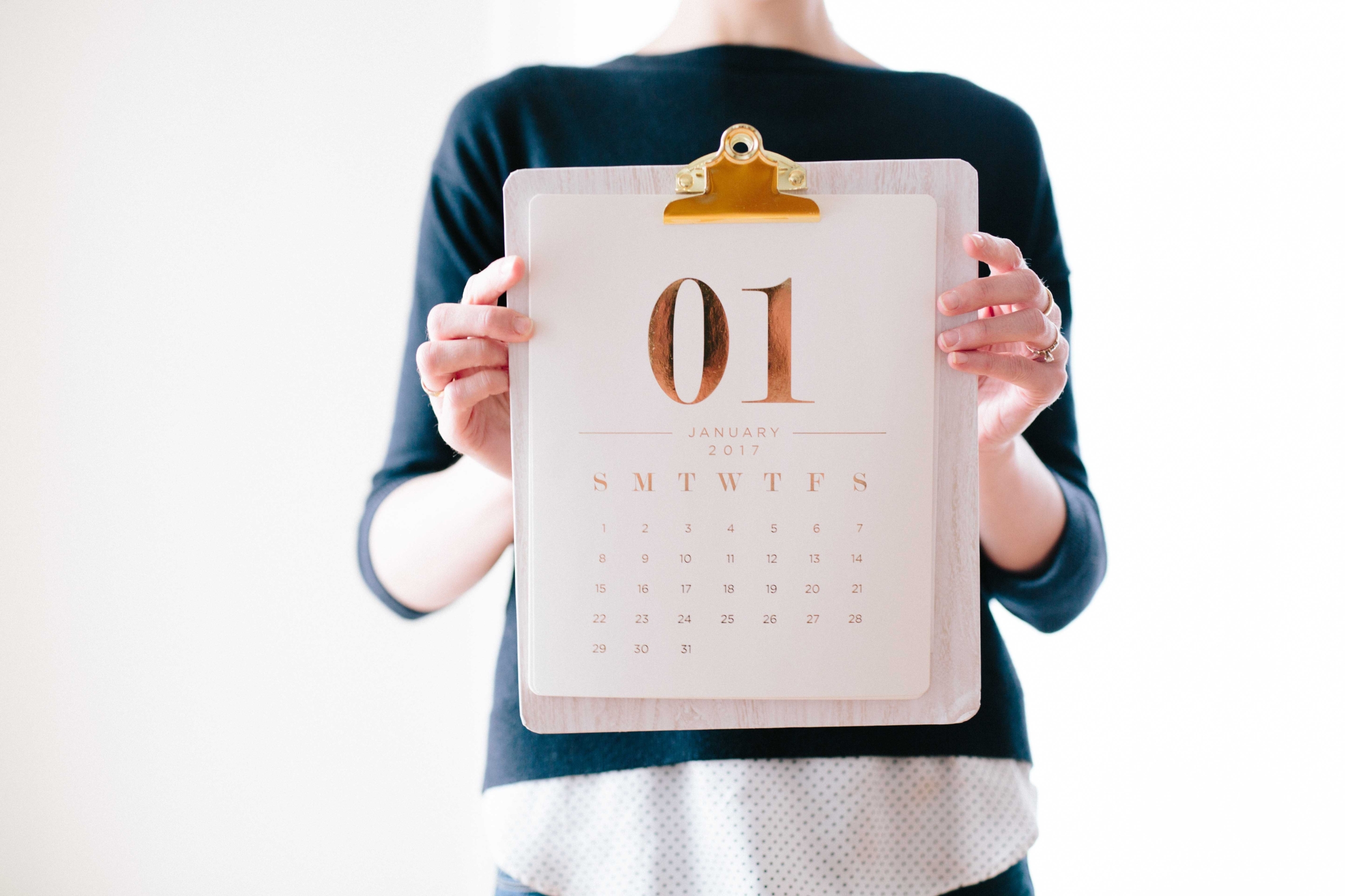 A woman holds a calendar that reads '01 January 2017'