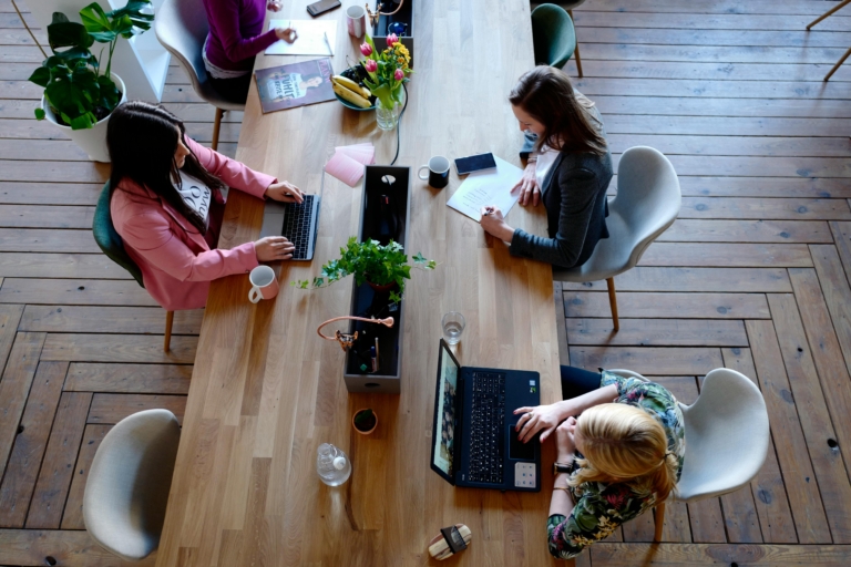 Four female workers work in a co working space