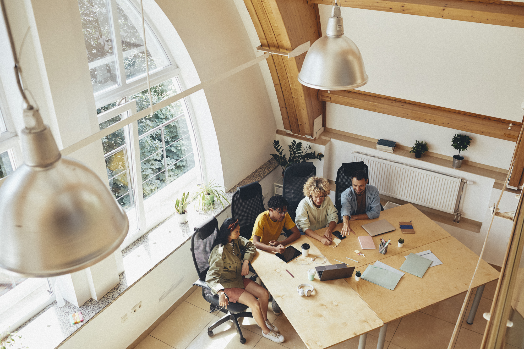 Group of programmers working at office Timpi team collaborating and sharing ideas in a bright, modern office setting.