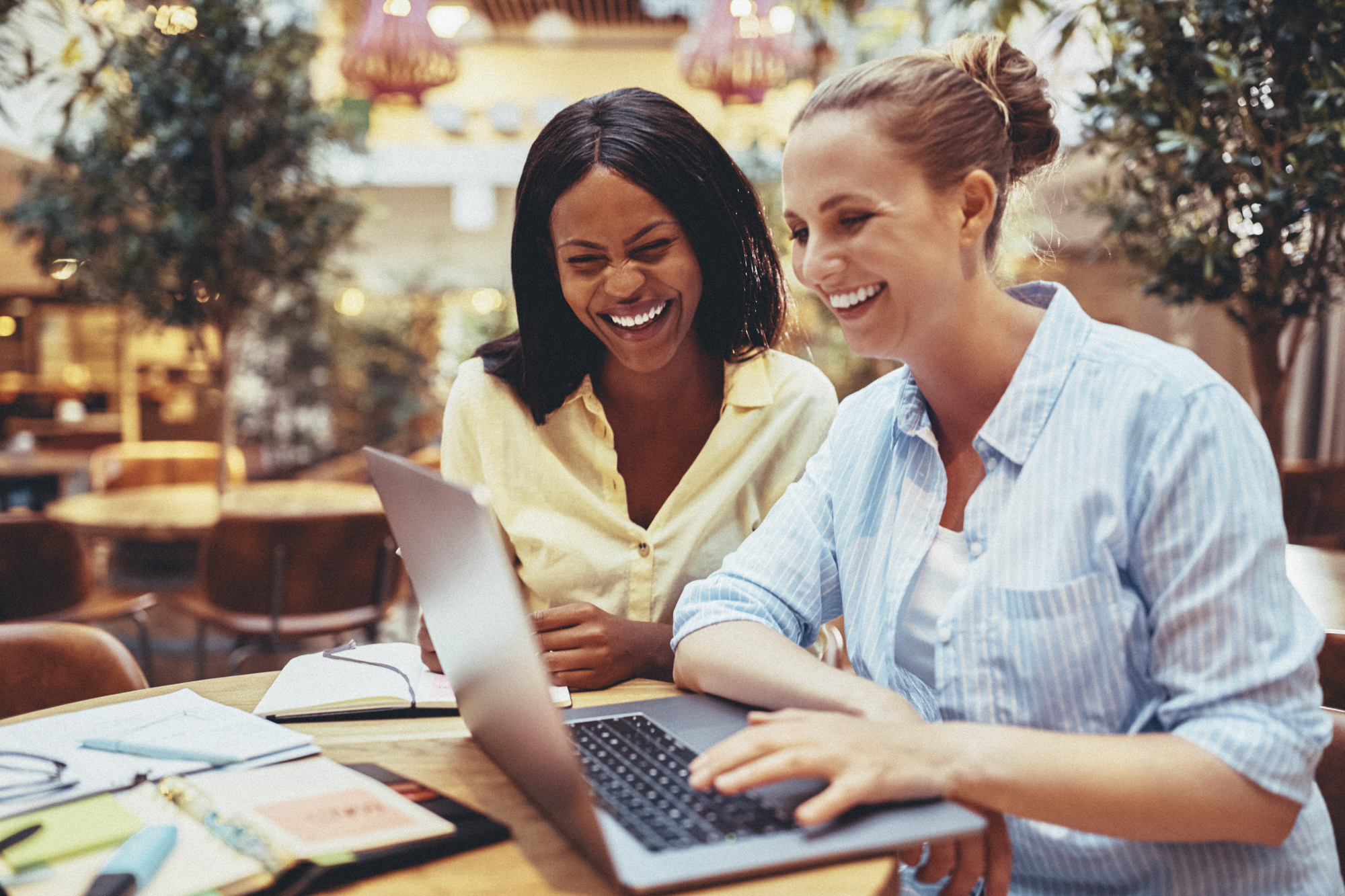 Sheargolds_2025-5 2 Timpi virtual assistants collaborating and smiling while working together in a bright workspace.