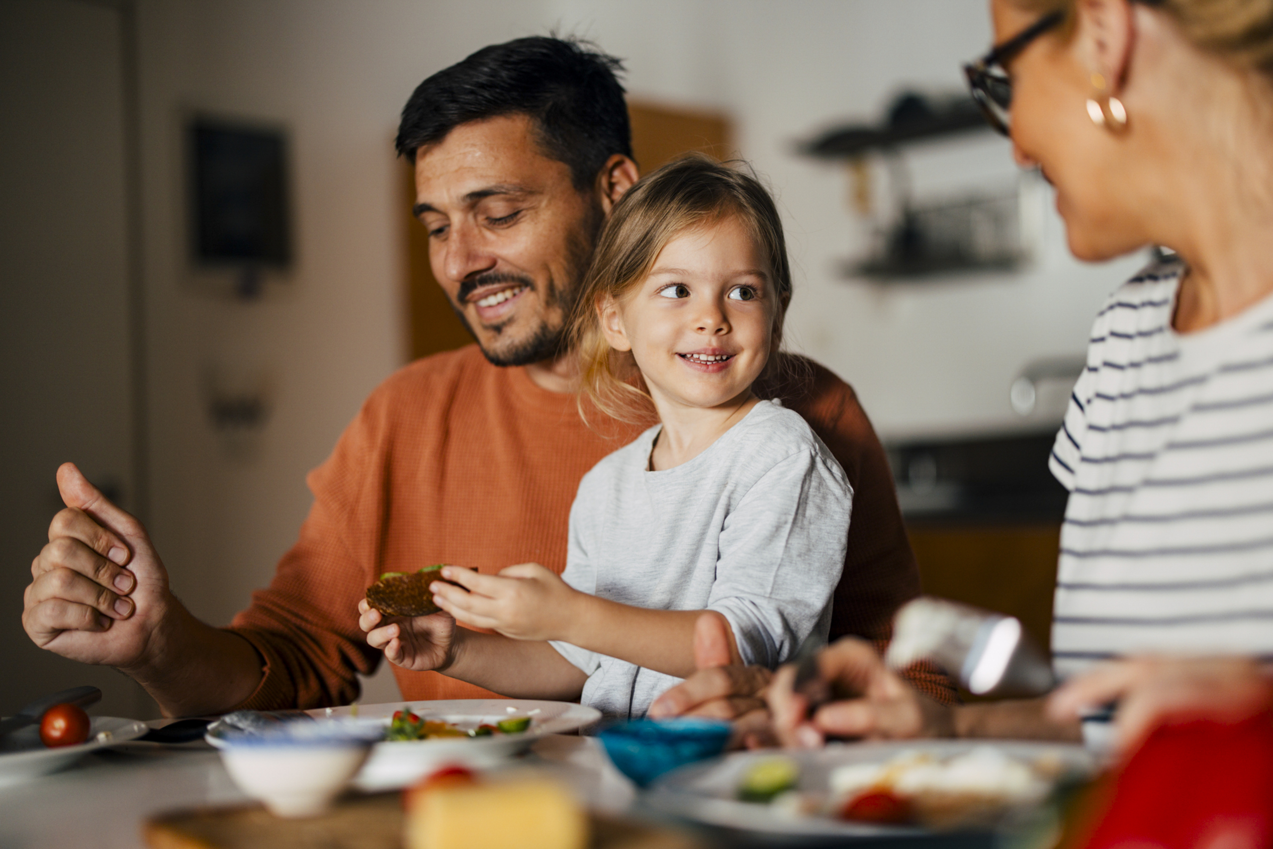 A family of three enjoy meal time together