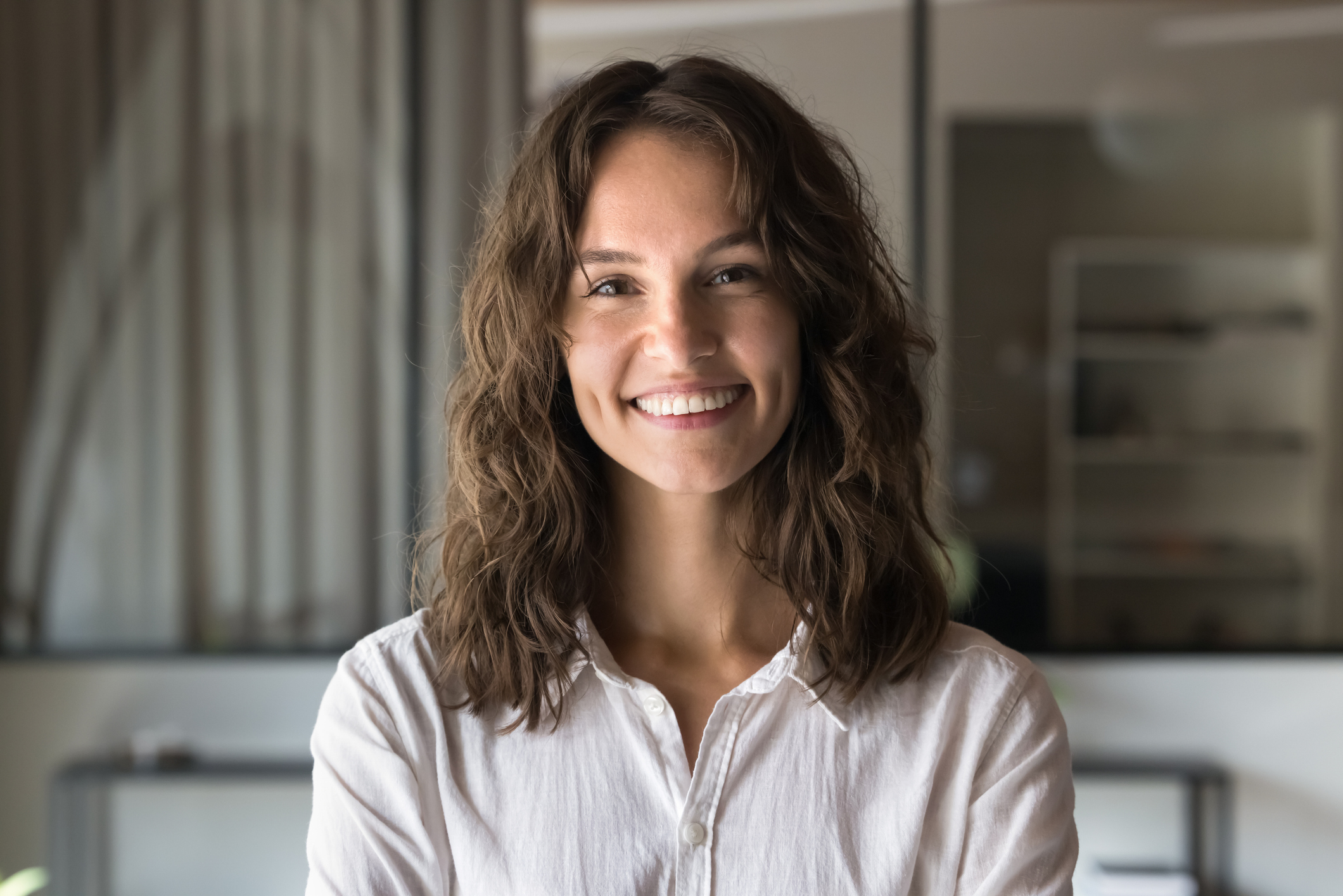 Head shot portrait of young female, wearing casual shirt looking at camera
