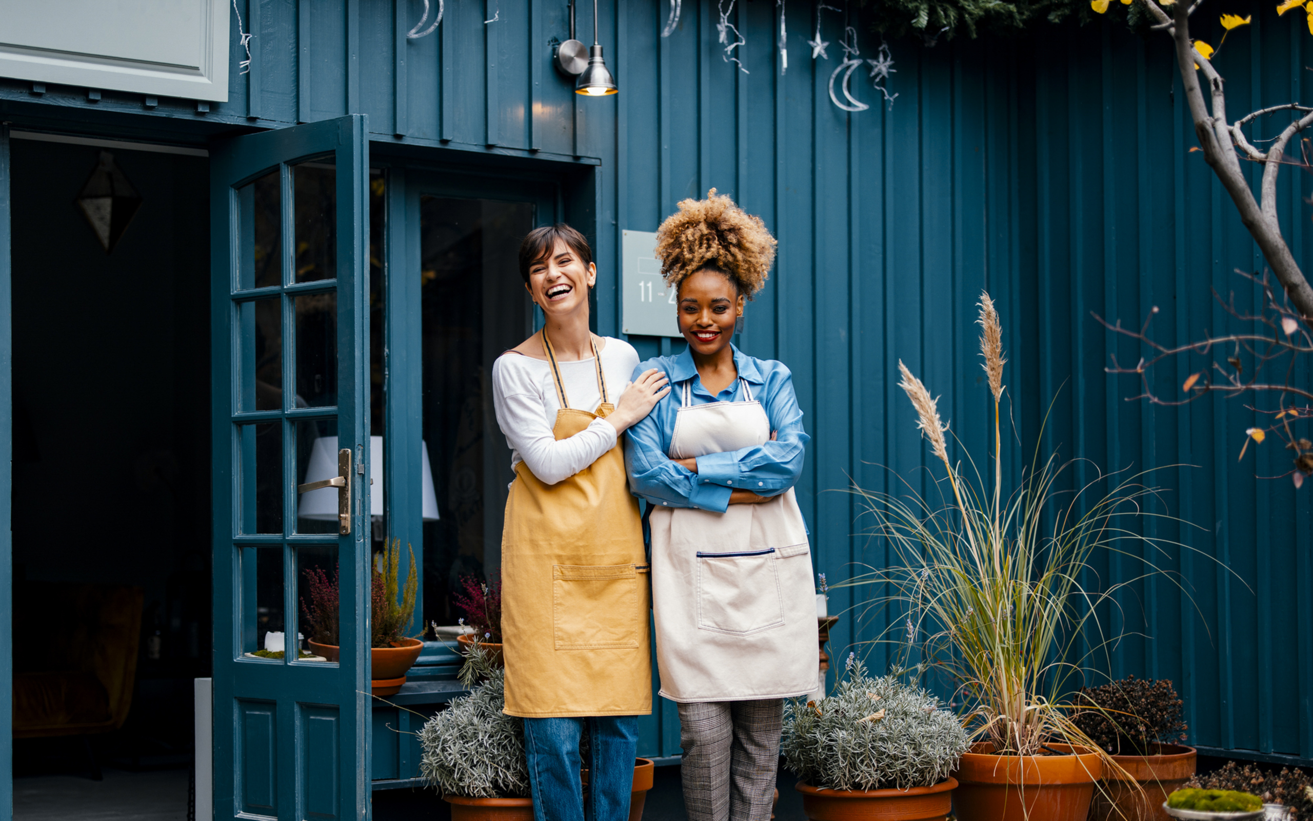 Portrait Of Two Happy Colleagues Working Together In A Home Decor Store