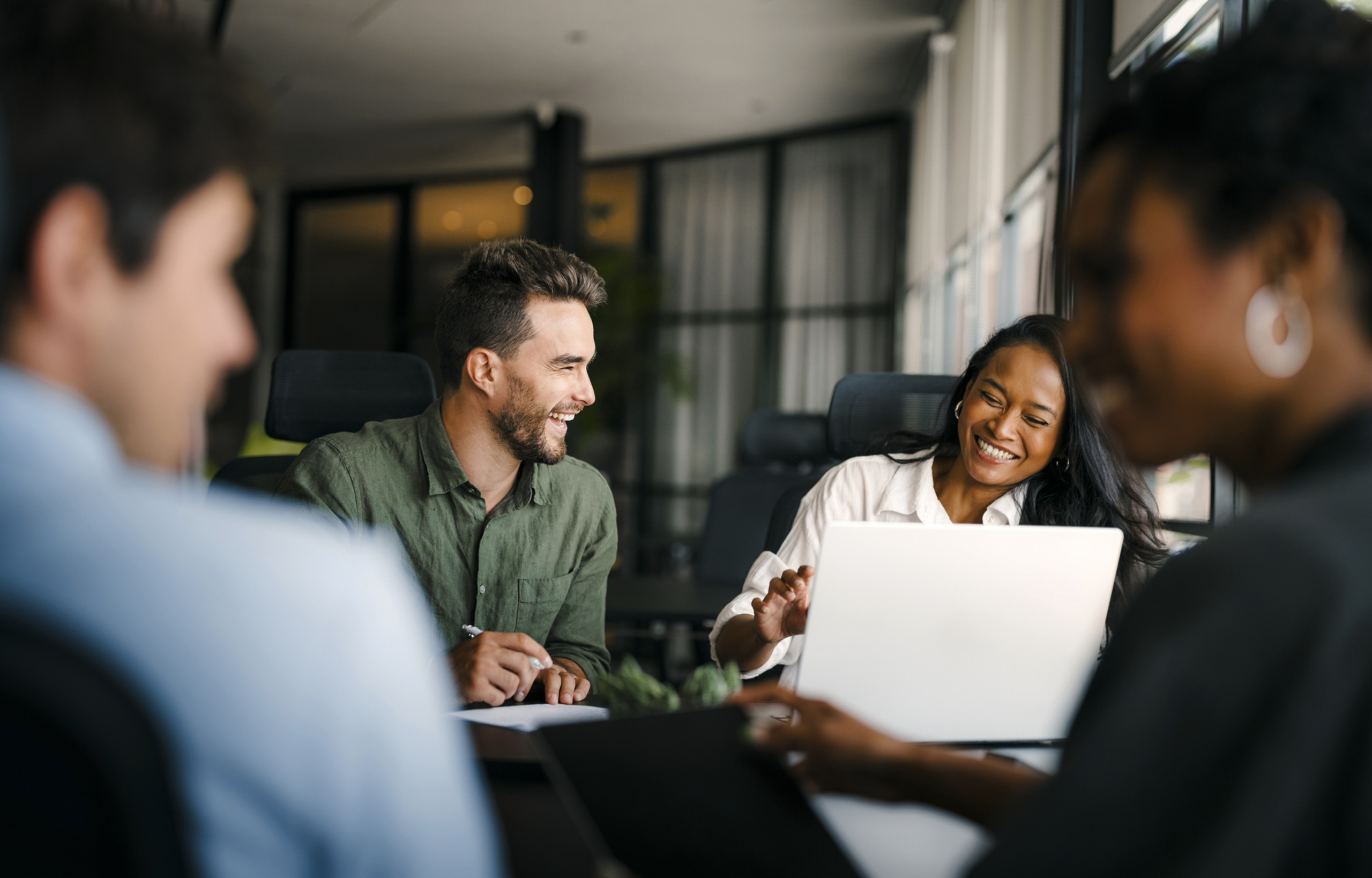 4 young professionals collaborate happily on a project