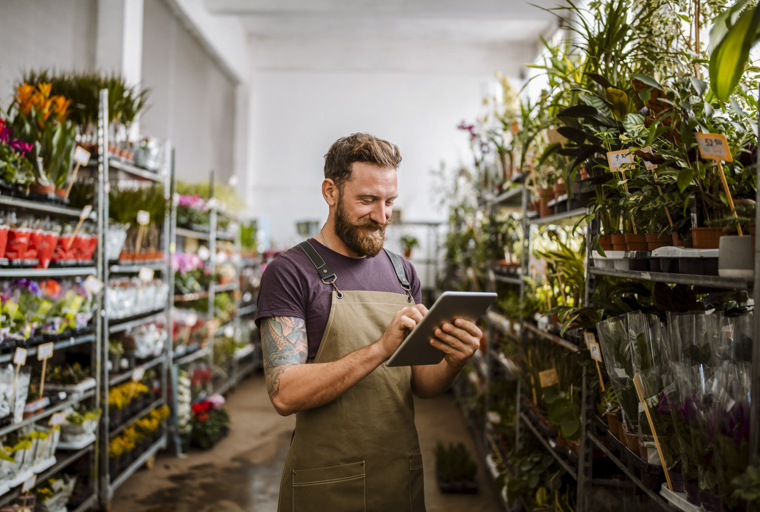 Male working in a florist shop using digital tablet