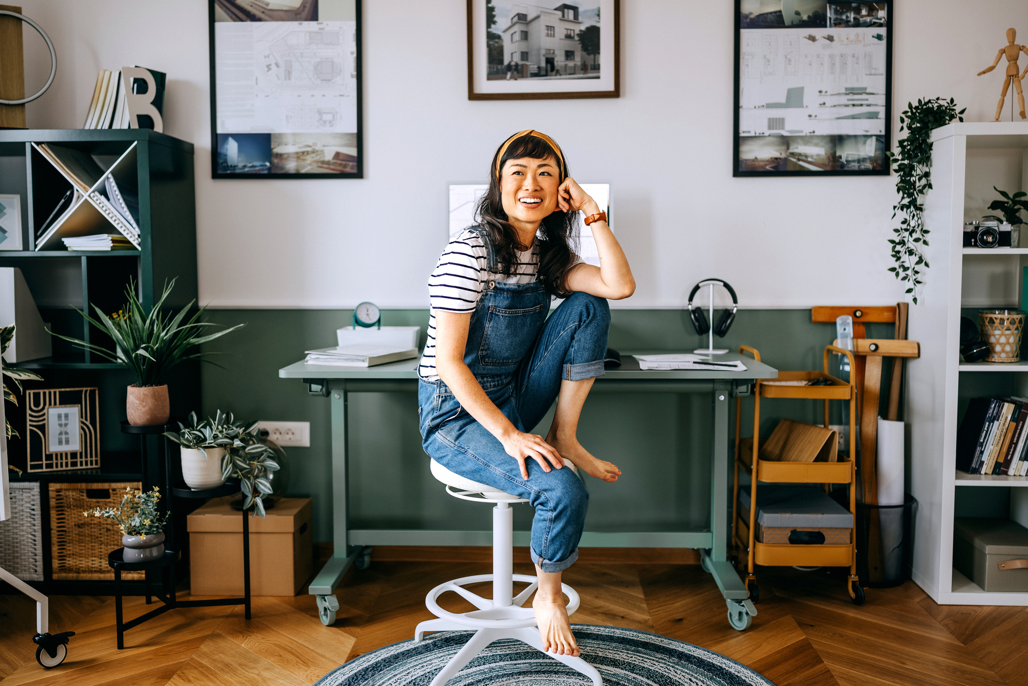 Portrait of cheerful casually clothed woman sitting at a desk at home office